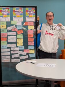 Ben Quick (he/they) standing by a board with lots of notes