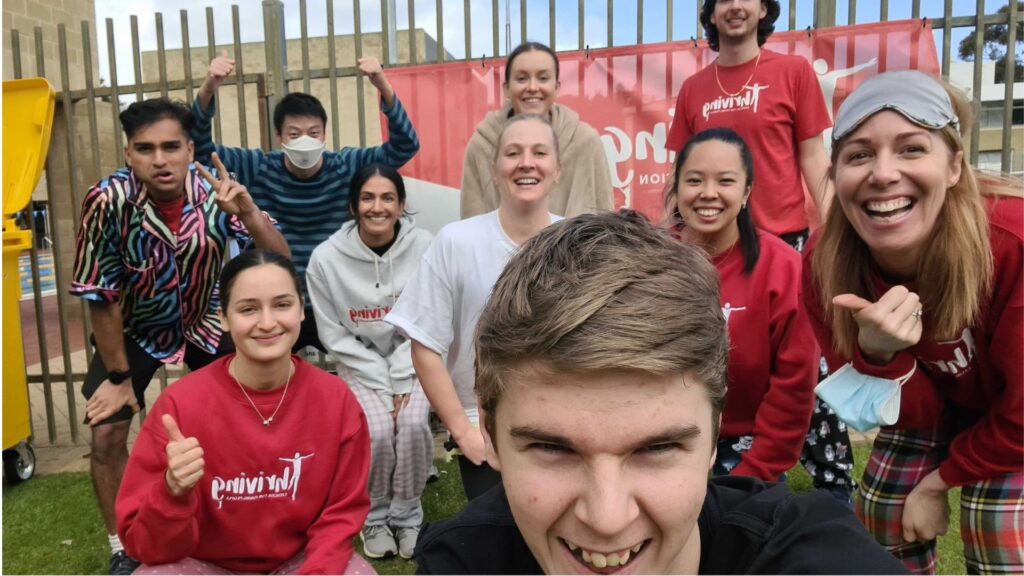 Thriving teen participant in front of shot taking a selfie with group of Thriving instructors behind him. All are smiling at the camera or giving thumbs up.
