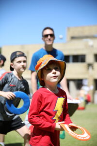 Two children concentrating on throwing with adult in the background