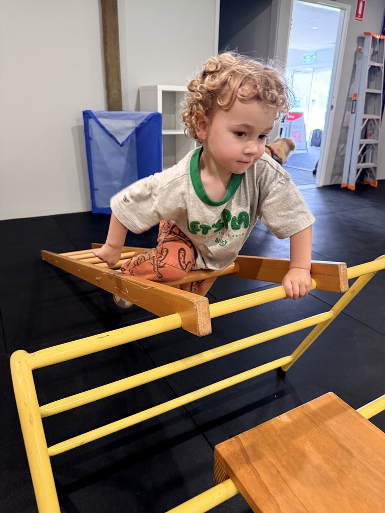 A child climbing the bouldering wall at Thriving HQ, Balcatta
