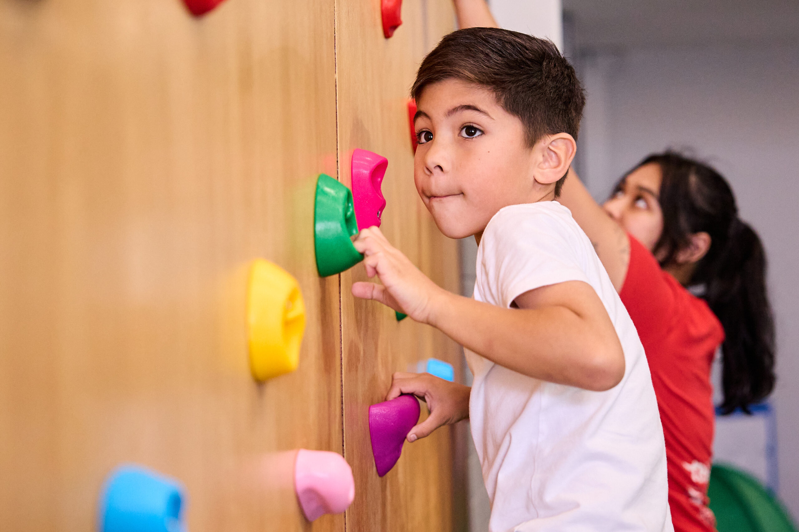A child climbing the bouldering wall at Thriving HQ, Balcatta